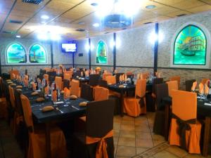 a dining room with tables and chairs and windows at Pension San Marcos in Alovera