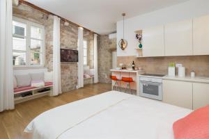 a kitchen with a large white bed in a room at That place studio apartment in Trogir