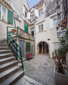 an alley in an old building with a bench at That place studio apartment in Trogir