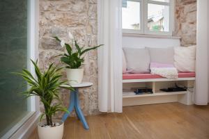 a bench in a room with two potted plants at That place studio apartment in Trogir