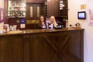 Dos mujeres sentadas en un mostrador en un bar en Veles Hotel, en San Petersburgo