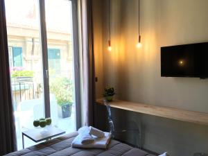 Una habitación con una cama y un televisor y una ventana. en Dimora Villareale, en Palermo