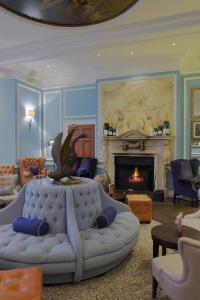 a woman sitting on a couch in a living room at Hotel du Vin Cannizaro House Wimbledon in London