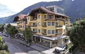 a large yellow building on the side of a street at MANNI das Hotel in Mayrhofen