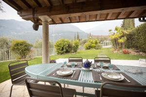 トスコラーノ・マデルノにあるVilla dei Coloriの青いテーブルと椅子付きのパティオ