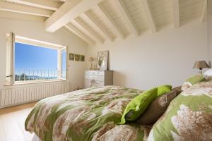 a bedroom with a bed with a view of the ocean at Villa dei Colori in Toscolano Maderno