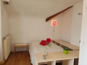 a room with a bed with a vase of flowers on a table at NDP Family (Ndong Du Pierrier) in Montigny-lès-Cormeilles +32 photos