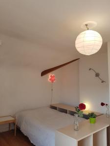 a bedroom with a bed and a lamp and a table at NDP Family (Ndong Du Pierrier) in Montigny-lès-Cormeilles