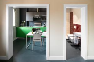 a kitchen with green cabinets and a table and chairs at Almarossa in Bologna