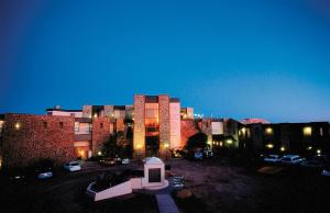 a large building with a parking lot in front of it at Desert Cave Hotel in Coober Pedy