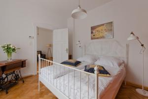 uma cama branca num quarto com uma secretária em Imperial Apartments - Moderna em Sopot