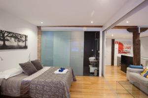 a bedroom with a large bed and a couch at Baps Apartments in Bilbao +89 photos