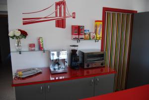 a kitchen with a red counter top with a microwave at Hotel Paradís in Torredembarra