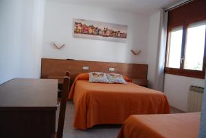 a hotel room with two beds with orange sheets at Hotel Paradís in Torredembarra