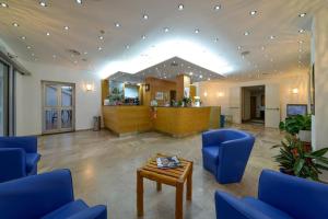 a large lobby with blue chairs and a table at Villa Nettuno in San Menaio