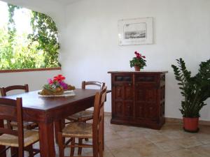 a dining room with a table and chairs and a cabinet at FICO D'INDIA in Lampedusa
