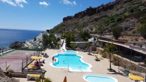 - une piscine sur une colline à côté de l'océan dans l'établissement Apartamento Sur Monseñor, à Playa del Cura