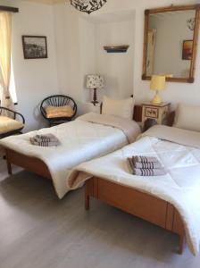 two beds in a room with a mirror at Toula's house 2 in Spetses +27 photos