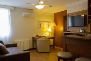 a living room with a couch and a table with a television at Flat em Gramado in Gramado