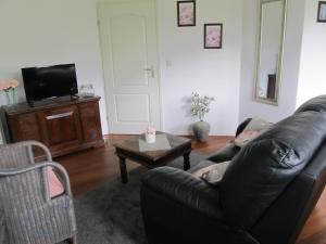 a man laying on a couch in a living room at Bed & Breakfast "Bij de Trekgaten" in Hollandscheveld