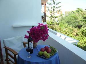 a table with a bottle of wine and a plate of fruit at Ioli Apartments in Naousa