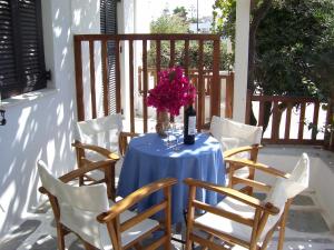 a table with a bottle of wine and flowers on it at Ioli Apartments in Naousa