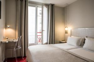 a bedroom with a bed and a desk and a window at Le Quartier Bercy-Square in Paris