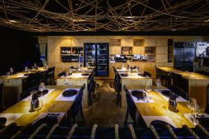 a restaurant with long wooden tables and chairs at De Pedra e Sal Hostel & Suites in Setúbal
