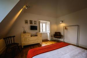 a bedroom with a bed and a dresser at De Pedra e Sal Hostel & Suites in Setúbal