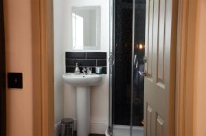 a bathroom with a sink and a glass shower at Frankies Wine Bar & Lodge in Disley