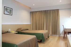 Postel nebo postele na pokoji v ubytování Charoen Hotel