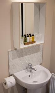 a bathroom with a sink and a mirror at The Swan Hotel Bar and Grill in Maldon