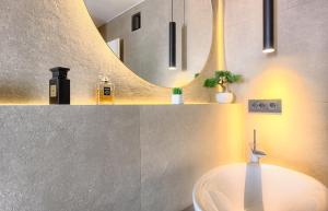 a bathroom with a sink and a mirror at Apartment Mondo Deluxe in Kaštela