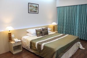 a hotel room with a large bed with pillows at Charoen Hotel in Udon Thani