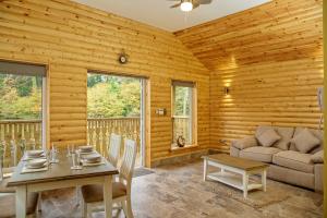a dining room with a table and a couch at Canada Lodge and Lake in Creigiau +20 photos