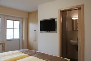 a bedroom with a bed and a sink and a television at Pension Am Ziegelwall in Bautzen