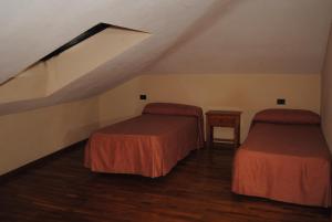 a attic room with two beds and a table at La Casona de Jovellanos in Gijón