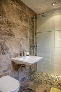 a bathroom with a sink and a glass shower at Canada Lodge and Lake in Creigiau