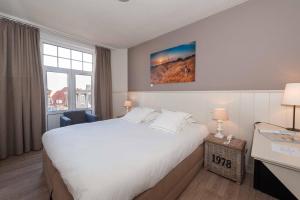 a hotel room with a large bed and a window at Hotel Heritage in De Haan
