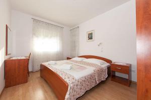 a bedroom with a large bed and a window at Apartment Meri Baska Voda in Baška Voda