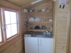 a kitchen with a sink in a wooden cabin at Smyrill Cottages in Þórshöfn