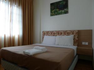 En eller flere senge i et værelse på Iris Apartment @ Iris House Resort