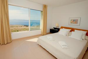 een slaapkamer met een bed en een groot raam bij Sweet Home Sa Rapita in Sa Ràpita