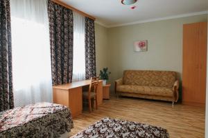 ヤロスラヴリにあるSkvoznoy pereulok 7のベッド1台、ソファ、窓が備わる客室です。
