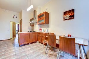 a kitchen with wooden cabinets and a table and chairs at Nevsky Prospect 107 in Saint Petersburg