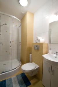 uma casa de banho com um WC, um chuveiro e um lavatório. em Zorza em Sztutowo