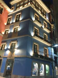 a blue building with windows and balconies at night at Estudio Azul Paraíso in Llanes