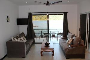 a living room with a couch and a table at Surfers Cove Apartments in Bel Ombre