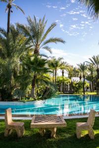 - une piscine avec 2 chaises, une table et un échiquier dans l'établissement Lodge K, à Marrakech
