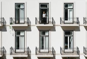 um homem está numa varanda de um edifício em The Lisboans Apartments em Lisboa